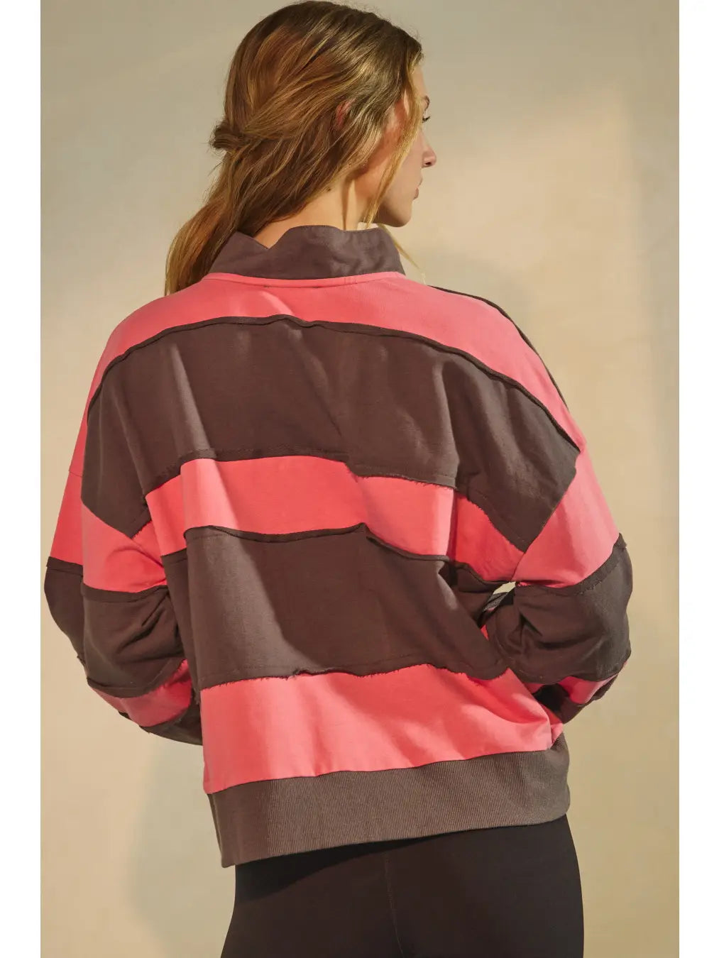 Washed color block pullover with grommet placket and raw-edge seams.