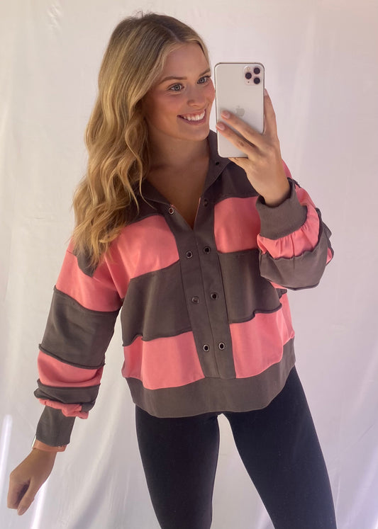 Washed color block pullover with grommet placket and raw-edge seams.