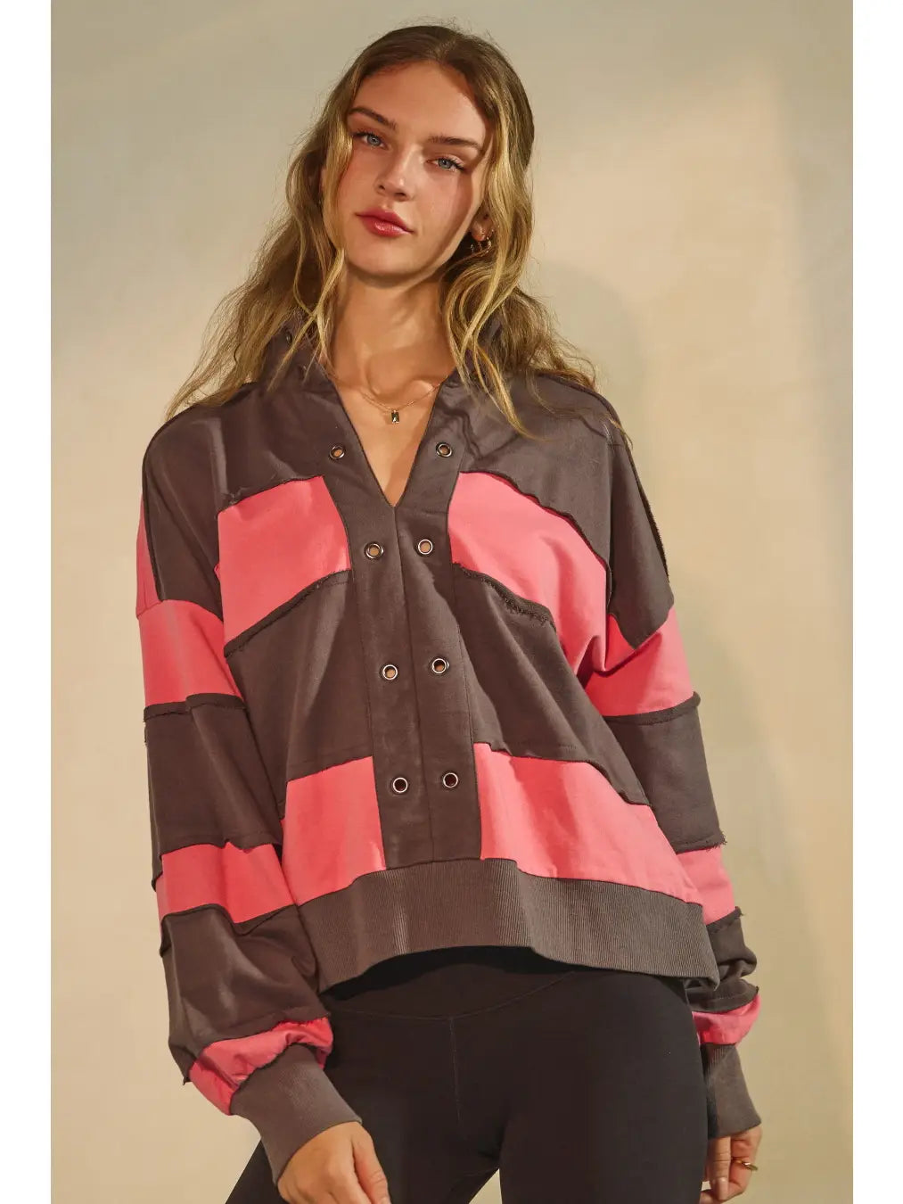 Washed color block pullover with grommet placket and raw-edge seams.